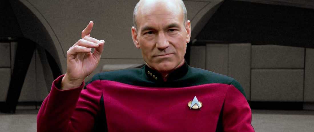 Captain Jean-Luc Picard is seated at his chair on the spaceship USS Enterprise.